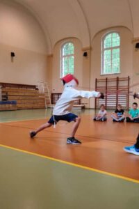 Dzieci podczas zajęć sportowych szermierczych.