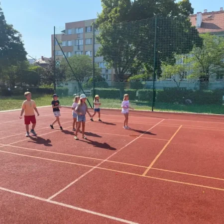Aktywne Półkolonie Wrocław Krzyki – dzieci grają w piłkę na boisku szkolnym podczas półkolonii letnich.