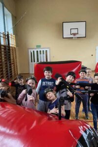 grupa dzieci pozująca do zdjęcia podczas gry w paintball laserowy