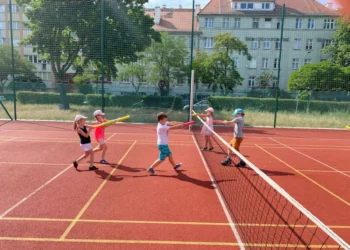 Dzieci bawią się na boisku, grając w gry wodne podczas półkolonii wrocławskich.