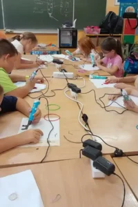 Dzieci uczestniczą w warsztatach z projektowania i druku 3D podczas Aktywnych Półkolonii we Wrocławiu.
